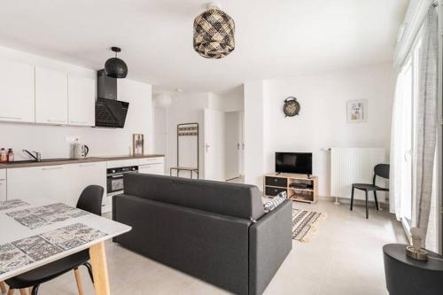 un salon avec un canapé et une cuisine dans l'établissement Home-like apartment Near DisneyLand, à Chessy