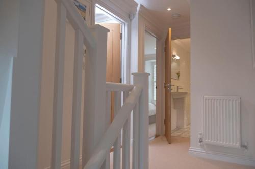 a white staircase in a room with a hallway at Chy An Gweal Farm Cottage in Carbis Bay