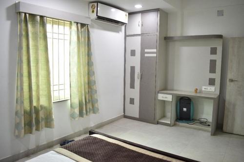 Habitación pequeña con cama y ventana en MAYUR HOTEL, en Dimāpur