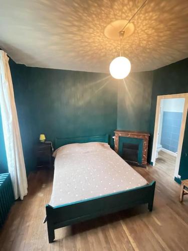ein Schlafzimmer mit einem Bett in einem Zimmer in der Unterkunft La cigalienne in Treignac