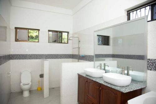 a bathroom with two sinks and a toilet at Masaki Seaside Charm: Spacious Hideaway in Dar es Salaam