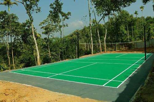 una pista de tenis en medio de un bosque en Noble Homestay en Munnar