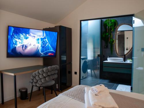 ein Schlafzimmer mit einem TV und ein Badezimmer mit einer Dusche in der Unterkunft NOVA LUXURY DESIGN in Zagreb
