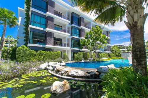 a hotel with a swimming pool in front of a building at The Title Boutique Phuket in Rawai Beach