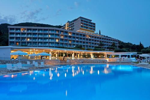 un hotel con piscina di fronte a un edificio di Atlantica Nissaki Beach - Adults Only a Gimari