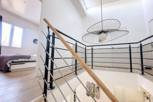 a staircase in a room with a ceiling fan at Maison familiale 140m² avec jardin in Saint-Ouen