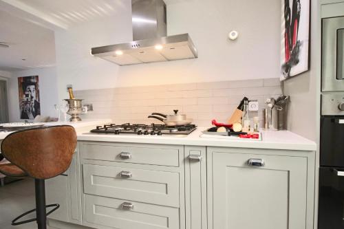 a kitchen with white cabinets and a stove top oven at Victoria Belgravia Apartments in London