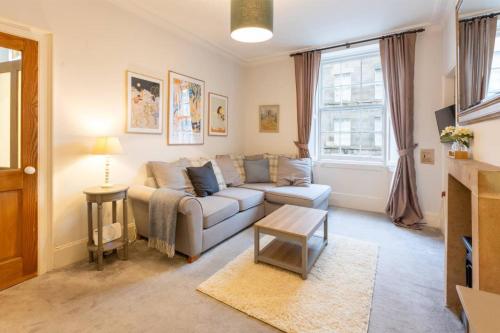 a living room with a couch and a table at Beautiful 1 Bedroom Flat in Vibrant Stockbridge in Edinburgh