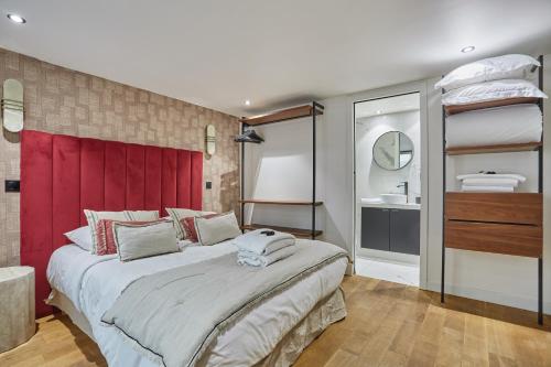 une chambre avec un grand lit avec une tête de lit rouge dans l'établissement Apartment St Honore by Studio prestige, à Paris