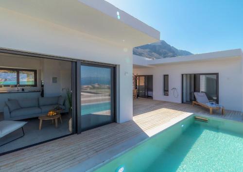 een huis met een zwembad en een woonkamer bij Villa Anna in Paleros