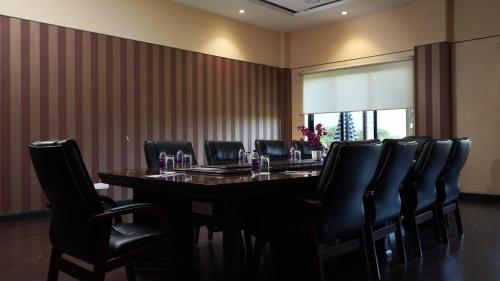 a conference room with a long table and black chairs at The Greenwood, Tezpur in Tezpur