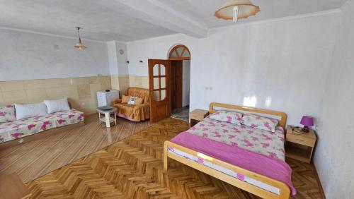 ein Schlafzimmer mit einem Bett und einem Sofa in der Unterkunft Karolina Guest House in Ohrid
