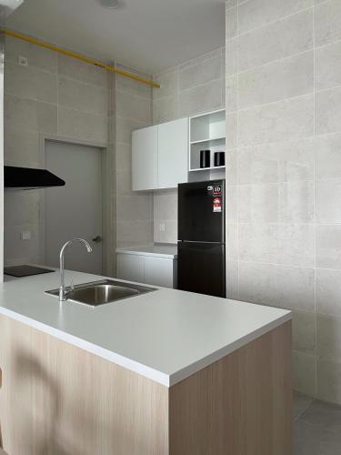 a kitchen with a sink and a black refrigerator at Non Smoking Theda Antara Putrajaya with Wifi and Netflix in Putrajaya