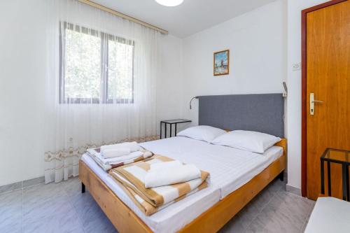 a bedroom with a large bed with towels on it at Apartments Janko Zarok in Baška