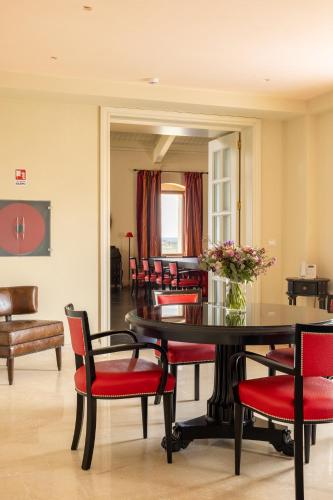 a dining room with a table and red chairs at Alvino Relais Mulino Contemporaneo in Matera