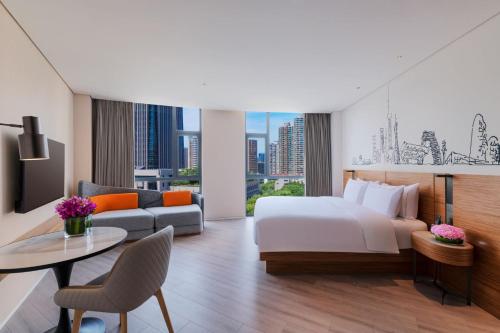 a hotel room with a bed and a table at UrCove by HYATT Shanghai Jing'An in Shanghai