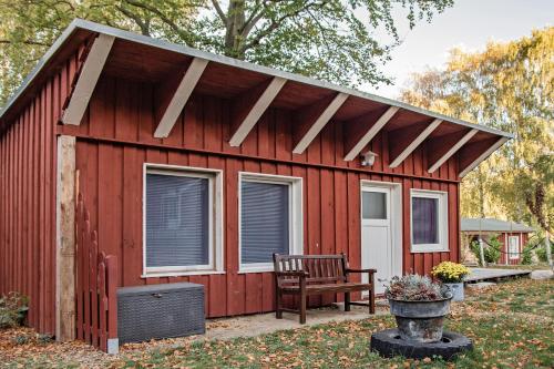 a red shed with a bench in the yard at Sturmmöwe in Ueckeritz