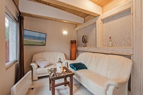 a living room with two white couches and a table at Sturmmöwe in Ueckeritz