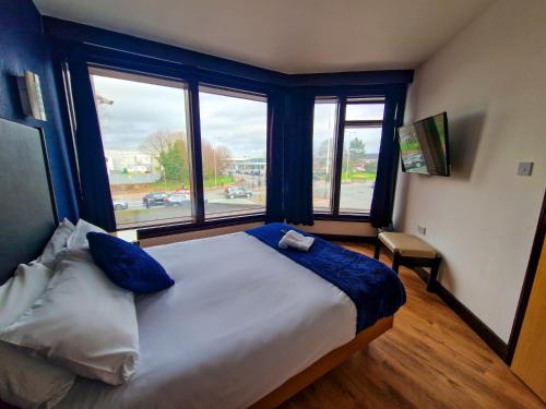 a bedroom with a large bed with a large window at Cornmill Hotel in Hull