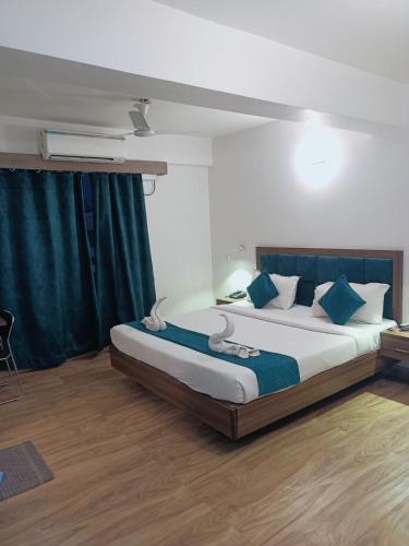 a bedroom with a large bed with blue pillows at CT ROOMS JAMAL ROAD by CLOVETREE in Patna