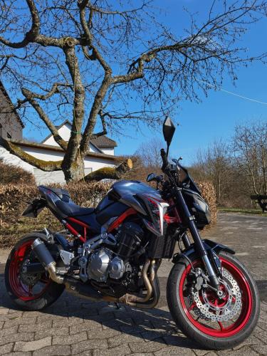 a motorcycle parked on a street next to a tree at Sauerland-AlmWinterberg in Hallenberg