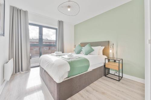a bedroom with a large bed and a large window at StayZeni, Hardwick House Derby Lovely 1 Bed Flat in Derby