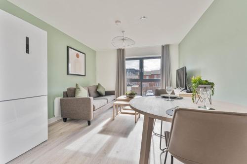 a kitchen and living room with a table and a couch at StayZeni, Hardwick House Derby Lovely 1 Bed Flat in Derby