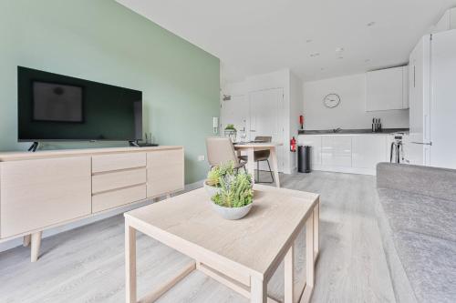 a living room with a table and a tv at StayZeni, Hardwick House Derby Lovely 1 Bed Flat in Derby