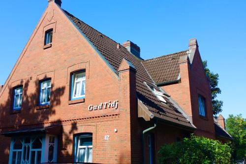 un edificio di mattoni con un orologio sul lato di Gud Tidj - Whg 03 a Wyk auf Föhr