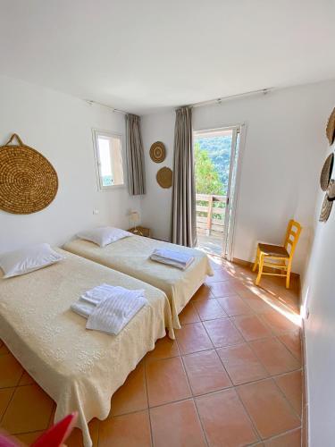 une chambre avec deux lits et un balcon dans l'établissement Les Terrasses de Scalegiu, à Porto-Vecchio