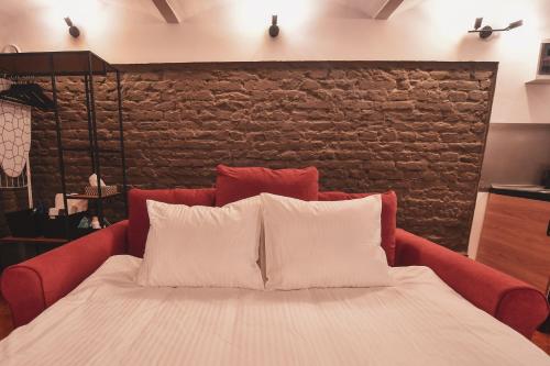 un letto rosso con due cuscini bianchi di Music Xperience Studio- comfy basement for Music Lovers a Timişoara