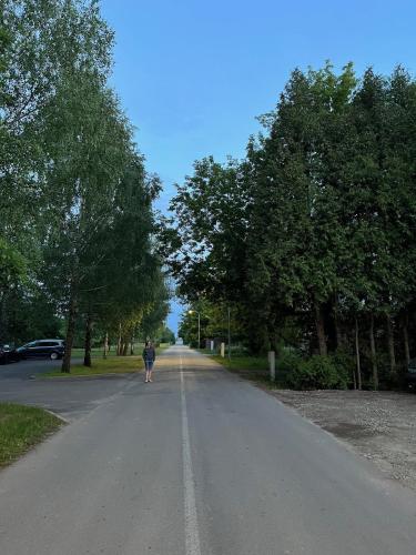 a person walking down a road in a park at Art&Comfort Country in Kaunas