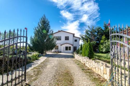 een wit huis met een hek en een oprit bij Appartement in Kapelica, Istria County mit Privatem Pool in Labin