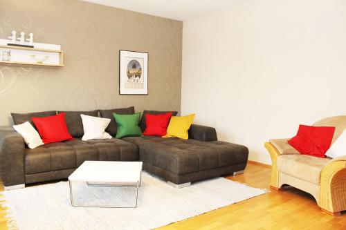 a living room with a brown couch with colorful pillows at Ferienwohnung Mühlenblick in Suderburg