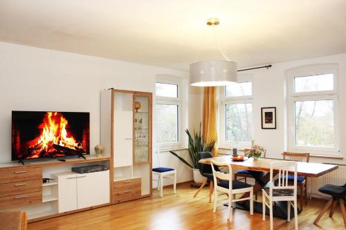 a living room with a table and a fireplace at Ferienwohnung Mühlenblick in Suderburg