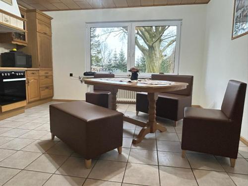 une cuisine avec une table et des chaises ainsi qu'une fenêtre dans l'établissement Ferienhaus Nannen, à Rechtsupweg