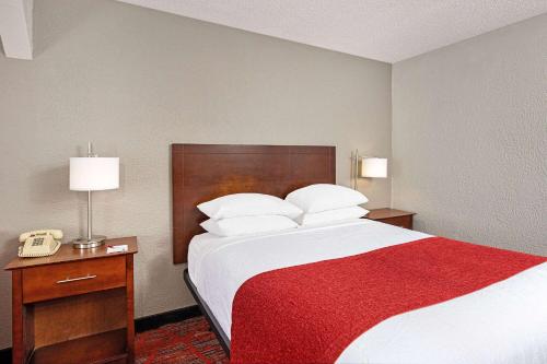 a hotel room with a large bed with a red blanket at Ramada by Wyndham Bowling Green in Bowling Green