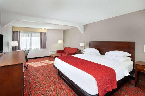 a hotel room with a large bed and a desk at Ramada by Wyndham Bowling Green in Bowling Green