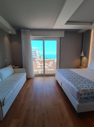 a bedroom with two beds and a view of the ocean at Hotel Concord - Nel cuore di Riccione in Riccione
