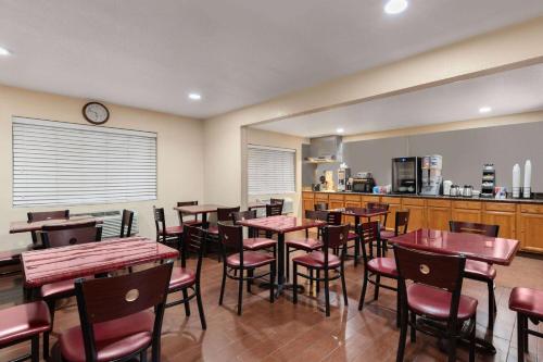a restaurant with tables and chairs and a kitchen at Howard Johnson by Wyndham Williams in Williams