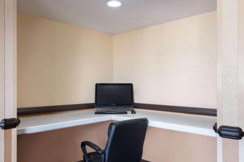 a room with a desk with a laptop on a shelf at Howard Johnson by Wyndham Williams in Williams