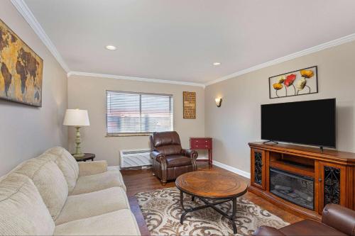 a living room with a couch and a flat screen tv at Ramada by Wyndham Bowling Green in Bowling Green