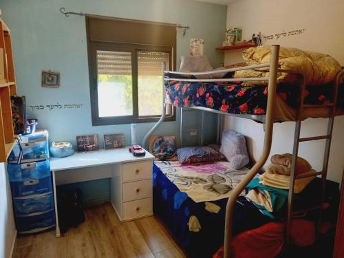 בוסתן בנגב في Netivot: غرفة نوم مع مكتب وسرير بطابقين