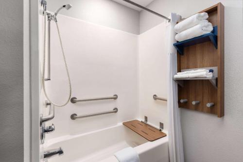 y baño con ducha y lavabo con toallas. en Microtel Inn and Suites Independence, en Independence
