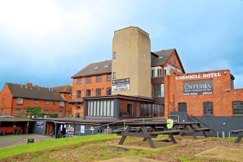 a group of picnic tables in front of a building at Cornmill Hotel in Hull