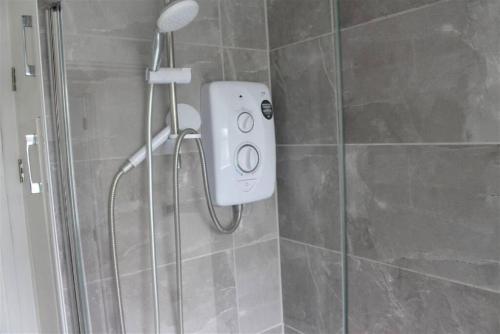 a shower with a shower head in a bathroom at Modern 2BR Apt Contractor stay in Hinckley
