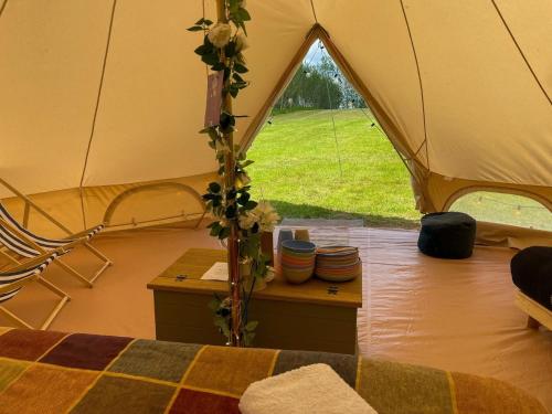 a tent with a bed and a table in it at Elm Bell Tent in Droitwich
