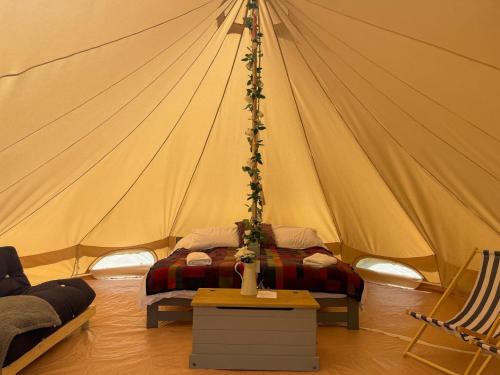 a bedroom with a tent with a bed in it at Elm Bell Tent in Droitwich