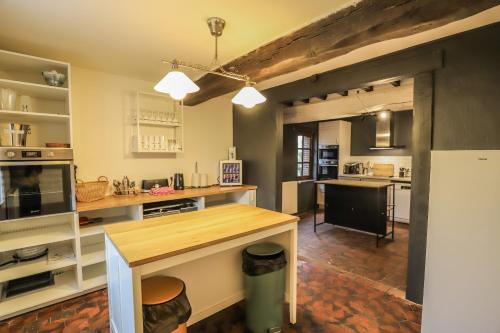 a kitchen with a wooden counter top in a room at Crazy Villa Champs Corons 61 - Interior heated pool - 2h from Paris - 30p in Les Menus