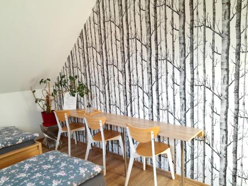 a dining room with a table and trees mural at Sowinka in Lutowiska